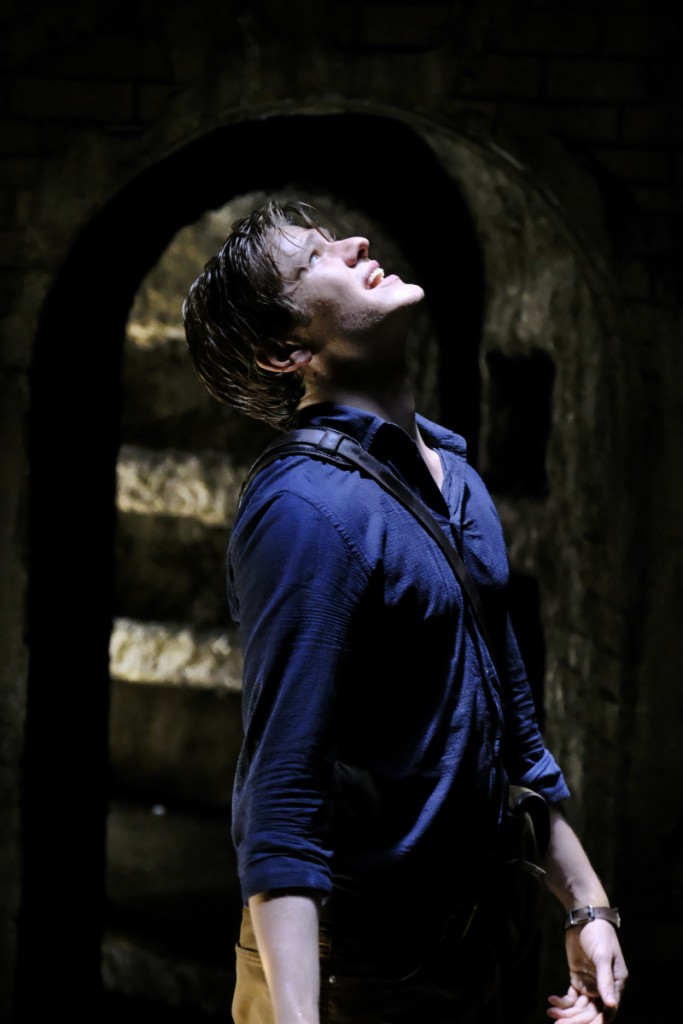 Mac (Lucas Till) se trouve dans des catacombes.