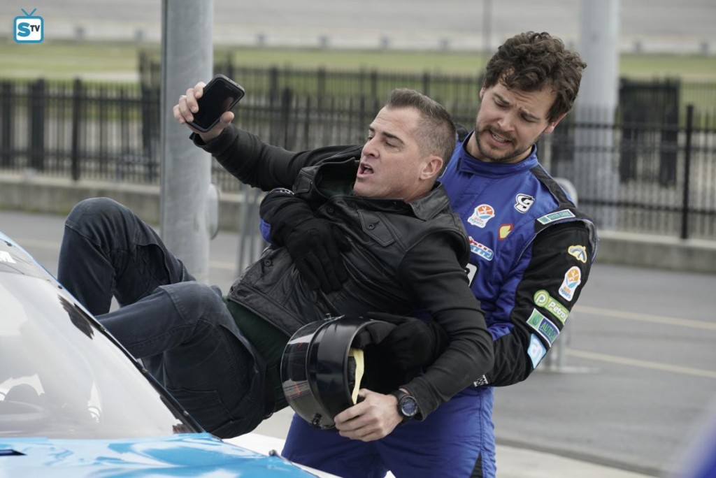Travis (Greg Perrow) aide Jack (George Eads) à sortir d'une voiture de course.