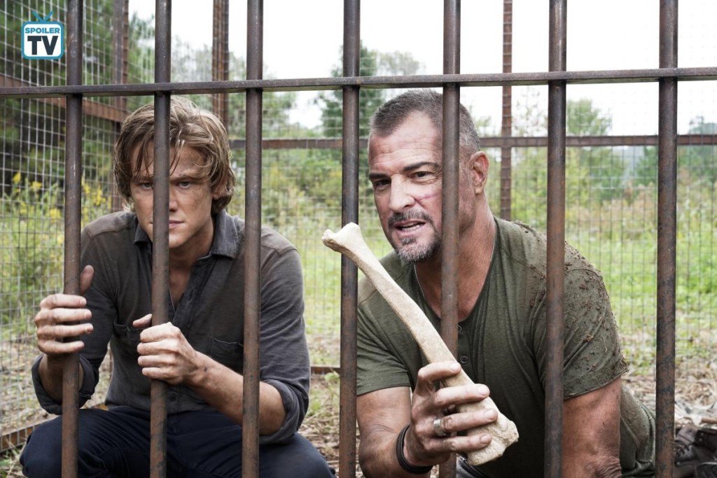 Mac (Lucas Till) et Jack (George Eads) sont retenus prisonniers dans une cage. Ce dernier cherche à appâter un chien avec un os.
