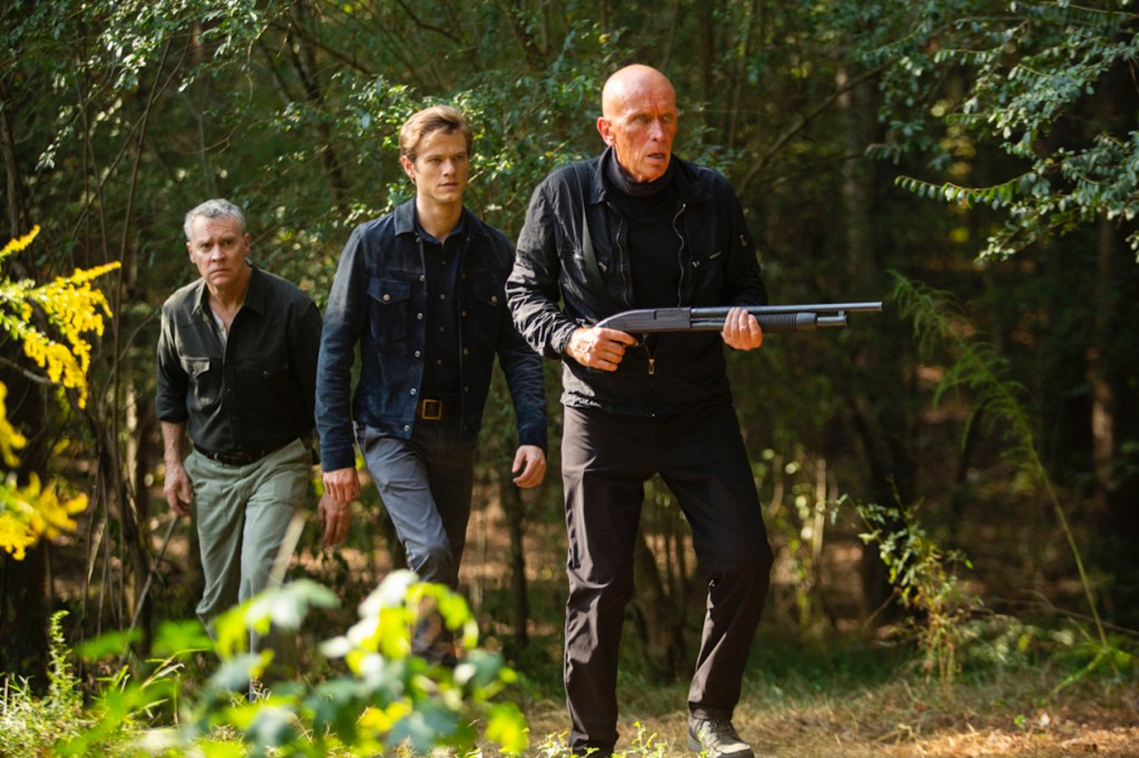 Alors que Mason (Peter Weller) est armé, Mac (Lucas Till) et Le Superviseur (Tate Donovan) le suivent dans la forêt.