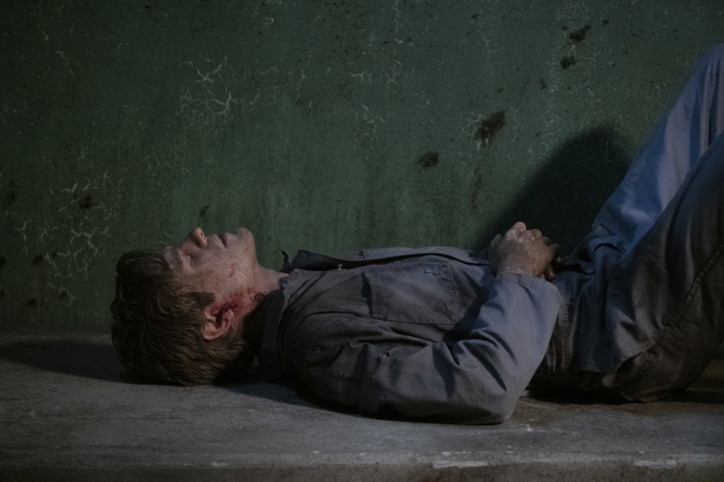 Mac (Lucas Till) est allongé sur le sol d'une cellule de prison.