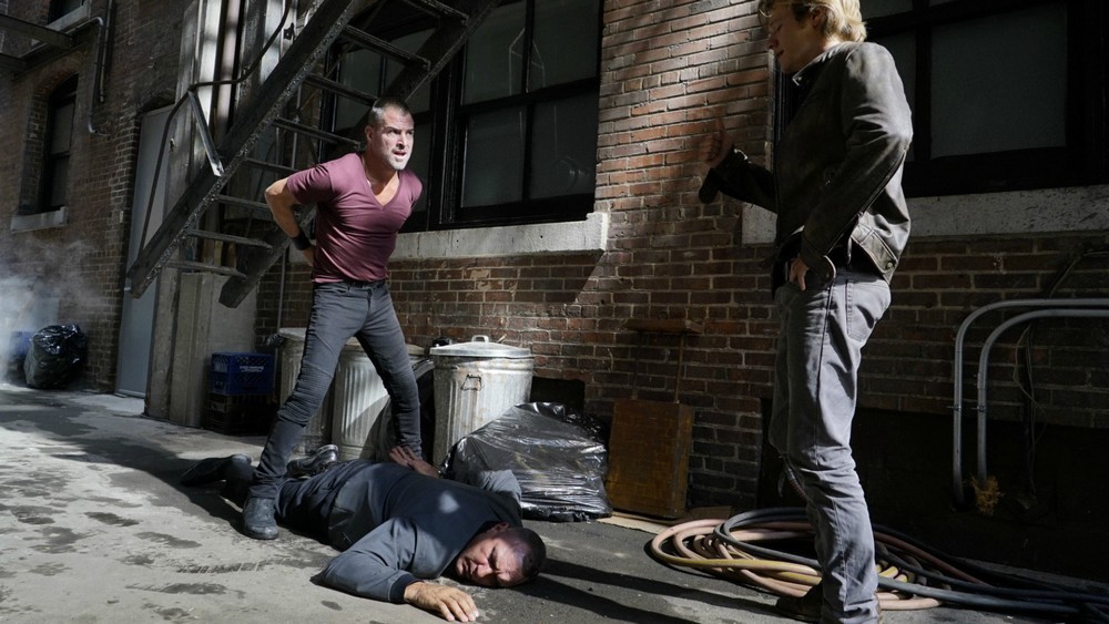 Jack (George Eads) vient d'arrêter un suspect sous le regard de MacGyver (Lucas Till).
