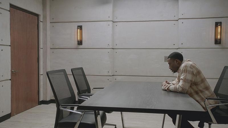 Bozer (Justin Hires) patiente dans une salle d’interrogatoire.